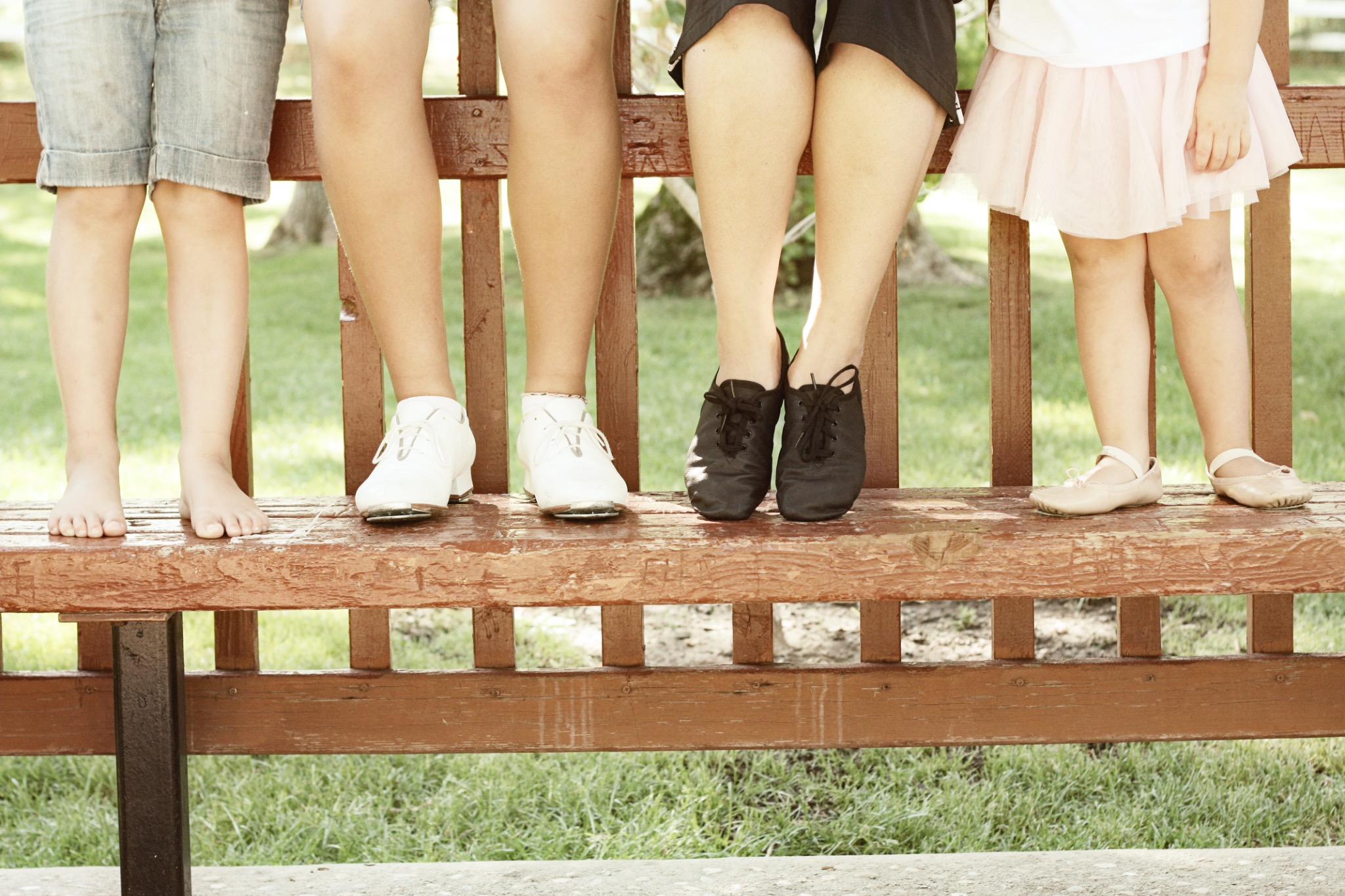 Four dancers wearing ballet, tap, and other dance shoes